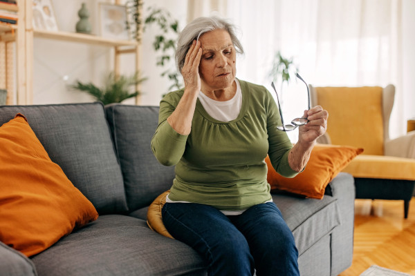 A woman holding hear head due to a bout of dizziness