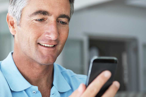 A middle-aged man looking at his cell phone